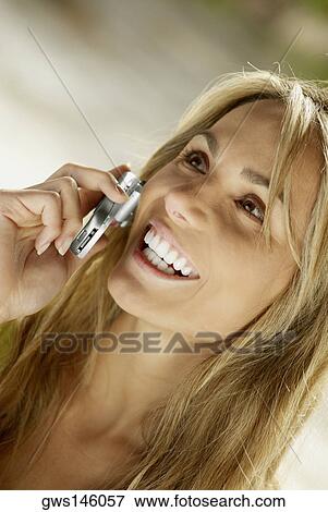 Close-up of a young woman talking on a mobile phone View Large Photo Image Stock Photo - Close-up of a young woman talking on a mobile phone. Fotosearch
