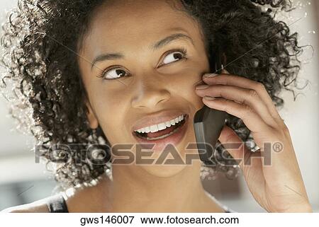 Stock Photo - Close-up of a young woman using a mobile phone. Fotosearch