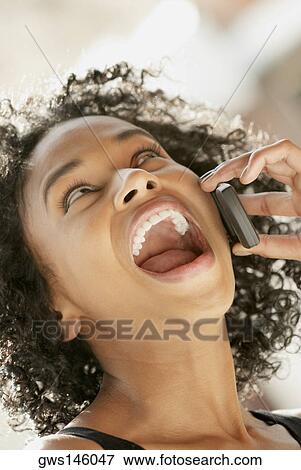 Stock Photo - Close-up of a young woman using a mobile phone. Fotosearch