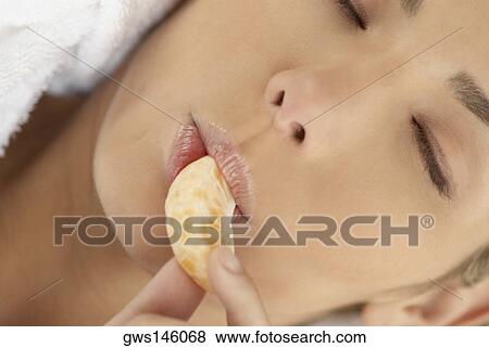 Close-up of a young woman with her eyes closed and eating an orange View Large Photo Image Stock Photo - Close-up of a young woman with her eyes closed and eating an orange. Fotosearch
