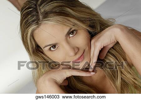 Close-up of a young woman with her hand on her chin View Large Photo Image Stock Image - Close-up of a young woman with her hand on her chin. Fotosearch