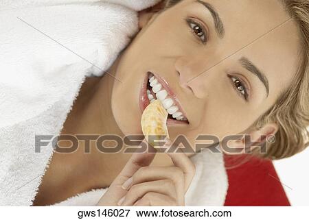 Portrait of a young woman eating an orange View Large Photo Image Stock Photo - Portrait of a young woman eating an orange. Fotosearch