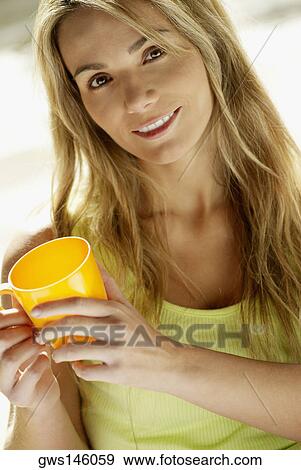 Portrait of a young woman holding a cup View Large Photo Image Stock Photo - Portrait of a young woman holding a cup. Fotosearch