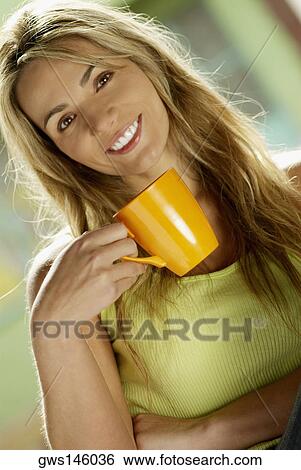 Portrait of a young woman holding a cup View Large Photo Image Stock Photograph - Portrait of a young woman holding a cup. Fotosearch