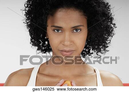 Portrait of a young woman holding a mango View Large Photo Image Stock Photography - Portrait of a young woman holding a mango. Fotosearch
