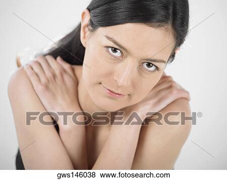Stock Photo - Portrait of a young woman hugging herself. Fotosearch