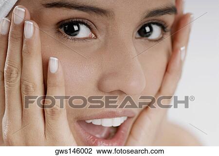 Portrait of a young woman looking surprised with her head in her hands View Large Photo Image Stock Image - Portrait of a young woman looking surprised with her head in her hands. Fotosearch