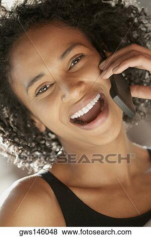 Stock Photo - Portrait of a young woman using a mobile phone. Fotosearch