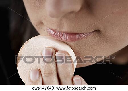 Close-up of a woman applying face powder on her chin with a powder puff View Large Photo Image Stock Image - Close-up of a woman applying face powder on her chin with a powder puff. Fotosearch