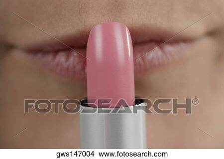 Close-up of a young woman applying lipstick View Large Photo Image Picture - Close-up of a young woman applying lipstick. Fotosearch