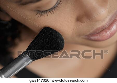 Close-up of a young woman applying blush with a brush View Large Photo Image Stock Image - Close-up of a young woman applying blush with a brush. Fotosearch