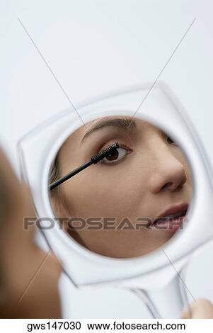 Close-up of a young woman applying mascara on her eyelashes View Large Photo Image Stock Image - Close-up of a young woman applying mascara on her eyelashes. Fotosearch