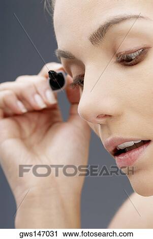 Close-up of a young woman applying mascara on her eyelashes View Large Photo Image Stock Image - Close-up of a young woman applying mascara on her eyelashes. Fotosearch