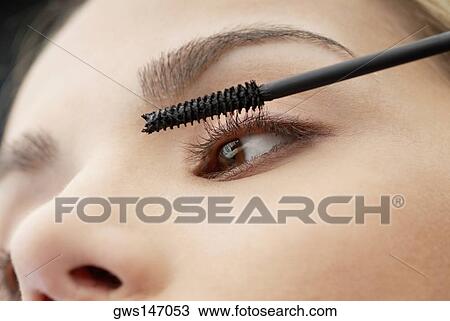 Close-up of a young woman applying mascara on her eyelashes View Large Photo Image Stock Image - Close-up of a young woman applying mascara on her eyelashes. Fotosearch