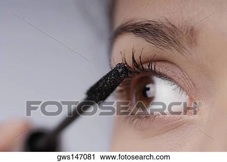 Close-up of a young woman applying mascara View Large Photo Image Stock Image - Close-up of a young woman applying mascara. Fotosearch