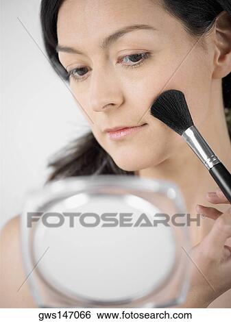 Close-up of a young woman applying blush with a brush View Large Photo Image Stock Photograph - Close-up of a young woman applying blush with a brush. Fotosearch