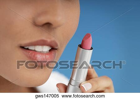 Close-up of a young woman holding a lipstick View Large Photo Image Stock Photography - Close-up of a young woman holding a lipstick. Fotosearch