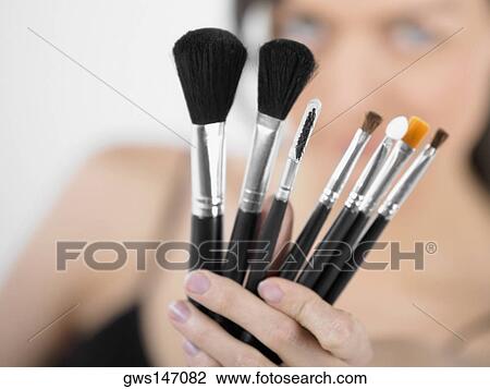 Close-up of a young woman holding make-up brushes View Large Photo Image Stock Image - Close-up of a young woman holding make-up brushes. Fotosearch