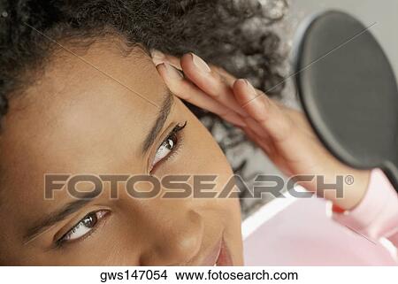 Close-up of a young woman looking into a hand mirror View Large Photo Image Picture - Close-up of a young woman looking into a hand mirror. Fotosearch