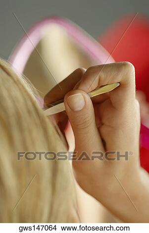 Close-up of a young woman tweezing her eyebrows View Large Photo Image Picture - Close-up of a young woman tweezing her eyebrows. Fotosearch