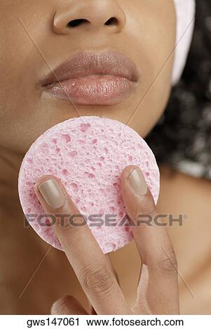 Close-up of a young woman using a powder puff View Large Photo Image Stock Image - Close-up of a young woman using a powder puff. Fotosearch