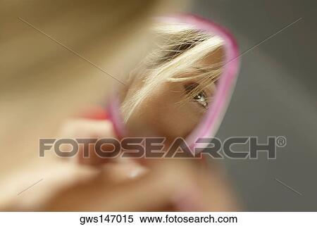 Close-up of a young woman's face in a vanity mirror View Large Photo Image Stock Photography - Close-up of a young woman's face in a vanity mirror. Fotosearch