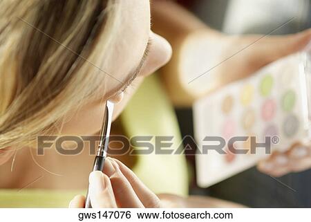 High angle view of a young woman applying eyeshadow View Large Photo Image Stock Photograph - High angle view of a young woman applying eyeshadow. Fotosearch