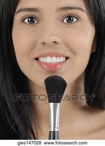 Portrait of a young woman applying blush with a brush View Large Photo Image Stock Photo - Portrait of a young woman applying blush with a brush. Fotosearch