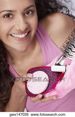Stock Photography - Portrait of a young woman holding a makeup bag. Fotosearch