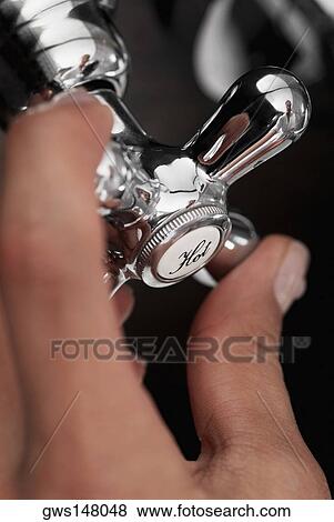 Close-up of a person's hand holding a faucet View Large Photo Image Stock Photo - Close-up of a person's hand holding a faucet. Fotosearch