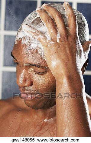 Stock Photography - Close-up of a young man scrubbing his head. Fotosearch
