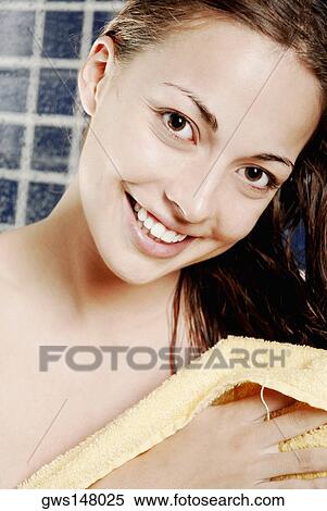 Stock Photography - Portrait of a young woman drying her hair with a hair dryer. Fotosearch