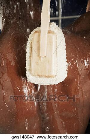 Rear view of a man scrubbing his back with a back brush View Large Photo Image Stock Photo - Rear view of a man scrubbing his back with a back brush. Fotosearch