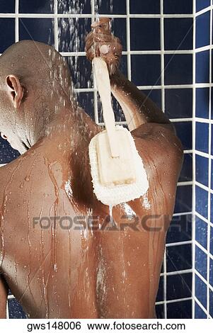 Rear view of a man scrubbing his back with a back brush View Large Photo Image Stock Photograph - Rear view of a man scrubbing his back with a back brush. Fotosearch