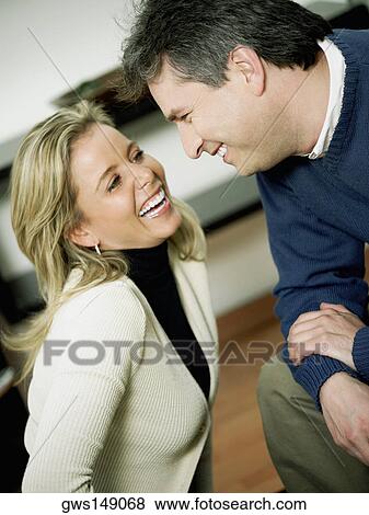 Close-up of a mature man and a mid adult woman looking at each other and smiling View Large Photo Image Stock Photo - Close-up of a mature man and a mid adult woman looking at each other and smiling. Fotosearch