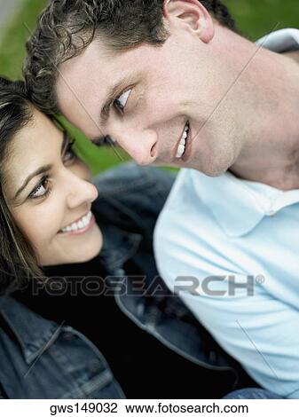 Close-up of a mid adult couple looking at each other and smiling View Large Photo Image Stock Image - Close-up of a mid adult couple looking at each other and smiling. Fotosearch