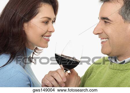 Picture - Close-up of a mid adult couple toasting glasses of wine. Fotosearch