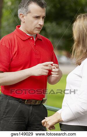 Close-up of a mid adult man gesturing to a mid adult woman View Large Photo Image Stock Photo - Close-up of a mid adult man gesturing to a mid adult woman. Fotosearch