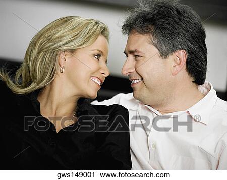 Close-up of a mid adult woman and a mature man looking at each other and smiling View Large Photo Image Stock Image - Close-up of a mid adult woman and a mature man looking at each other and smiling. Fotosearch