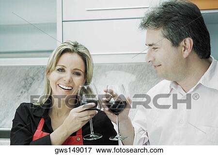 Close-up of a mid adult woman and a mature man toasting glasses of wine and smiling View Large Photo Image Stock Photo - Close-up of a mid adult woman and a mature man toasting glasses of wine and smiling. Fotosearch