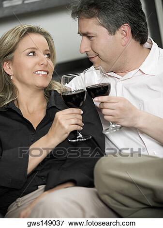 Stock Photo - Close-up of a mid adult woman and a mature man looking at each other and smiling. Fotosearch