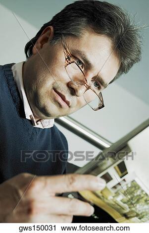 Close-up of a mature man reading a magazine View Large Photo Image Stock Image - Close-up of a mature man reading a magazine. Fotosearch
