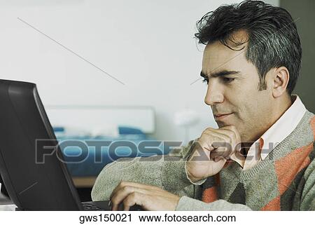 Stock Image - Close-up of a mature man using a laptop. Fotosearch