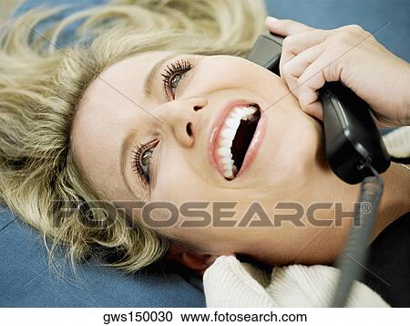 Close-up of a mid adult woman talking on the telephone and smiling View Large Photo Image Stock Image - Close-up of a mid adult woman talking on the telephone and smiling. Fotosearch