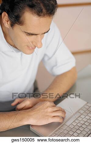 High angle view of a young man using a laptop View Large Photo Image Stock Photography - High angle view of a young man using a laptop. Fotosearch