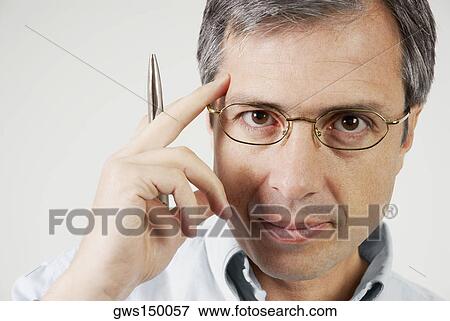 Portrait of a mature man holding a pen and thinking View Large Photo Image Stock Photo - Portrait of a mature man holding a pen and thinking. Fotosearch