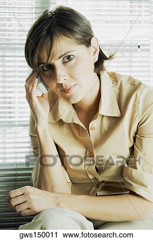 Stock Image - Portrait of a mid adult woman talking on a mobile phone. Fotosearch