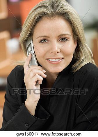 Stock Photo - Portrait of a mid adult woman talking on a mobile phone. Fotosearch