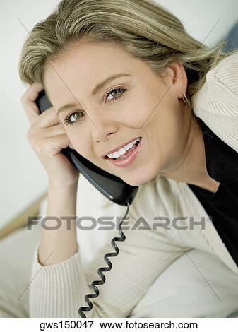 Portrait of a mid adult woman talking on the telephone and smiling View Large Photo Image Stock Photo - Portrait of a mid adult woman talking on the telephone and smiling. Fotosearch