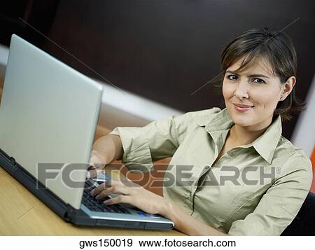 Portrait of a mid adult woman using a laptop View Large Photo Image Stock Photo - Portrait of a mid adult woman using a laptop. Fotosearch